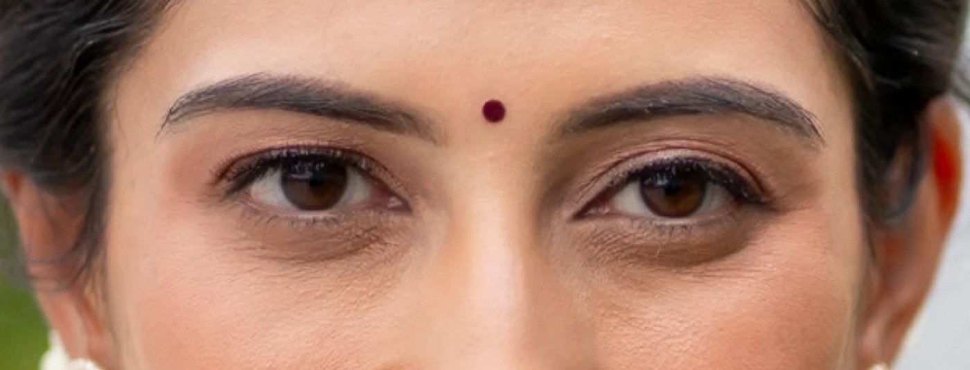 Close-up of the same portrait: her eyes, lashes and brows with a red bindi